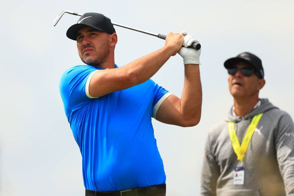 Brooks Koepka and his coach watching a shot